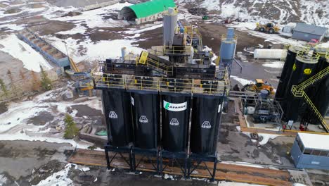 Girando-Alrededor-De-Los-Grandes-Silos-Negros-Hay-Un-Punto-De-Vista-Aéreo-De-Drones-De-La-Planta-De-Cemento-Calgary-Lafarge-Y-Sus-Alrededores