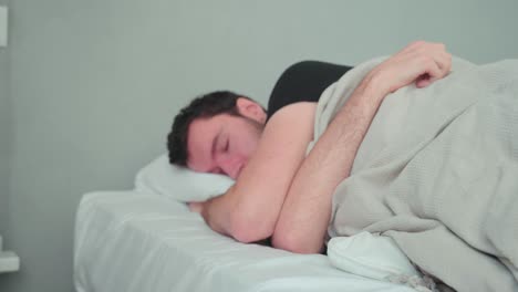 Sleeping-man,-caucasian-white-with-beard,-young-man-lying-in-bed-sleeping-dreaming,-uncomfortable-pillow,-turn-over-in-sleep