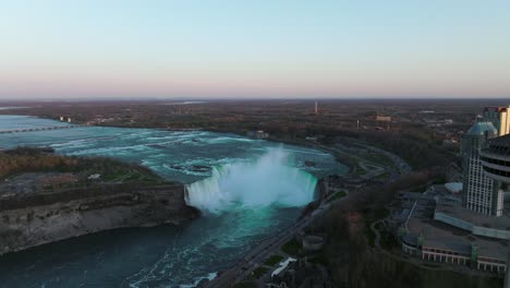 Niagarafälle-Von-Kanada-Seite-Mit-Aussichtsturm-Während-Des-Sonnenuntergangs,-Drohne-Fliegt-Rückwärts