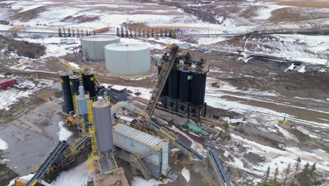 Girando-Alrededor-De-Los-Silos-Negros-Hay-Un-Punto-De-Vista-Aéreo-De-Drones-De-La-Planta-De-Cemento-Calgary-Lafarge-Y-Sus-Alrededores