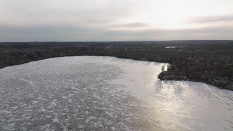 Gefrorener-Canadina-see-Wilcox-Nahe-Toronto-Im-Frühen-Frühling,-Drohne-Aufsteigend,-Stadtpanorama