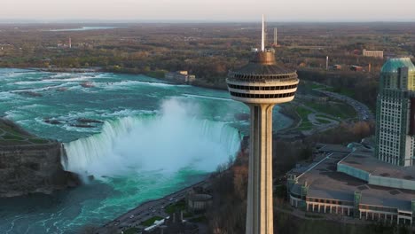 Niagarafälle-Von-Der-Kanadischen-Seite-Mit-Aussichtsturm-Während-Des-Sonnenuntergangs,-Drohne-Steigt-Auf-Und-Neigt-Sich-Nach-Unten