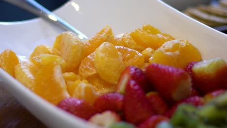 Close-up-shot-of-kiwi,-strawberries-and-oranges-in-bowl
