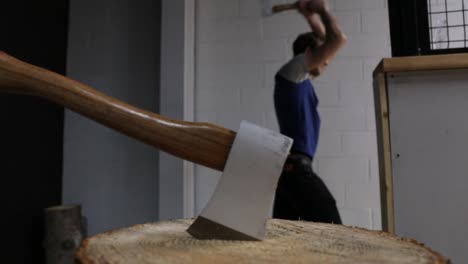 Axe-on-a-Log-While-Man-Throws-Axe-in-Axe-Throwing-Arena