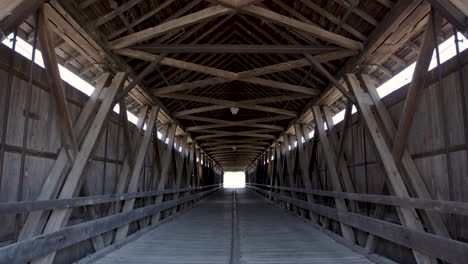Interior-of-Old-Wooden-Covered-Bridge-Panning-Down-from-Ceiling-in-Center