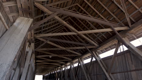 Interior-of-Old-Wooden-Covered-Bridge-Panning-Down-from-Ceiling-in-Center
