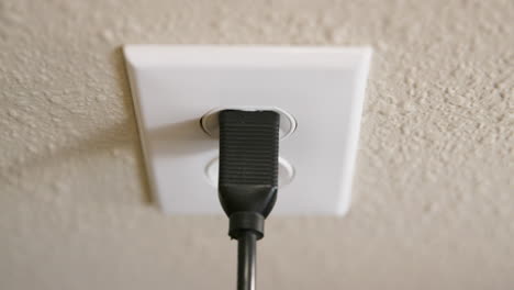 Close-Up-of-Man's-Hand-Plugging-Cord-Into-Electrical-Outlet-Then-Unplugging-in-Slow-Motion