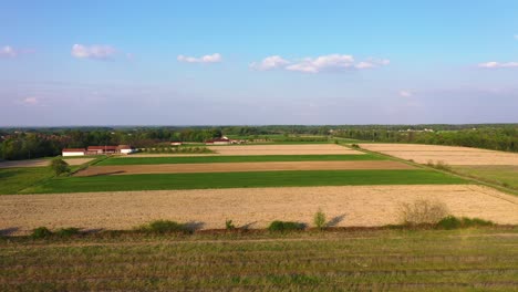 Wunderschönes-Luftbild-Eines-Kleinen-Dorfes-In-Bosnien,-Das-über-Weizenfelder-Und-Landwirtschaftliche-Orte-Fliegt