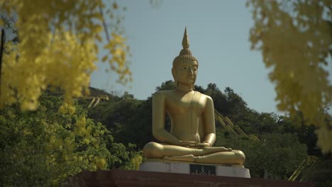 A-golden-seated-Buddha-statue-surrounded-by-yellow-flowers