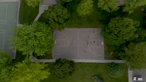 Kids-playing-basketball-in-the-park-shot-from-above-and-slowly-pushing-in-towards-them