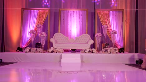 A-forward-moving-shot-of-a-love-seat-place-on-a-stage-for-a-wedding-reception