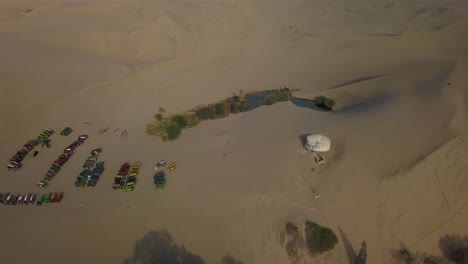 4K-aerial-shot-of-the-dune-buggies-in-Huacachina,-Peru