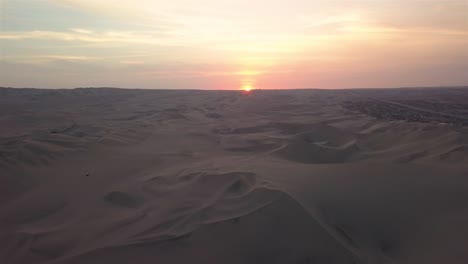 4K-aerial-shot-of-the-sand-dunes-at-sunset-in-Huacachina,-Peru