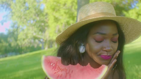 Schwarze-Frau,-Die-Beißende-Wassermelone-Isst-Und-Ein-Picknick-Im-Park-Genießt