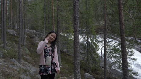 Girl-waveing-in-the-forest,-near-a-waterfall