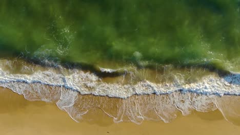 Top-View-of-Waves-Breaking-into-a-Sandy-Beach