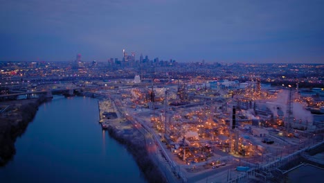Early-morning,-4K-aerial-footage-of-the-Philadelphia-skyline-with-an-industrial-plant-in-the-foreground