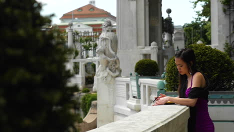 Mujer-Asiática-Parada-En-Un-Balcón-Renacentista-Escribiendo-En-Un-Libro-A-Cámara-Lenta