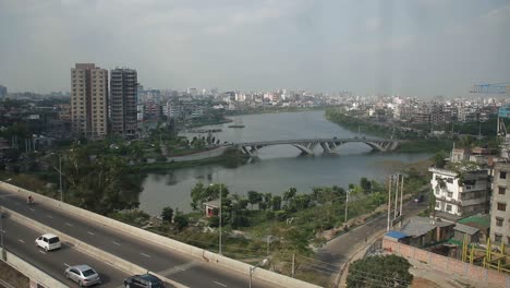 Schöne-Draufsicht-Der-Dhaka-stadt,-über-Brücke-Mit-See,-Gebäuden-Und-Autotransport