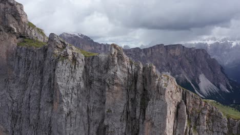 Seceda-ridge-with-reveal-of-rain-storm-in-Dolomite-mountains,-close-up-aerial-view