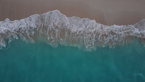 Aerial-top-down-shot-of-green-and-blue-tropical-ocean-waves
