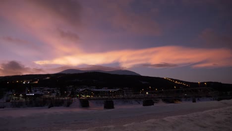 Pan-shot-of-a-beautiful-pink-sunset-in-a-snowed-town-of-Norway