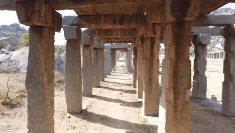 Tracking-Shot-Through-Collonade-of-Ruined-Temple-at-Hampi,-Karnataka,-India