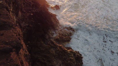 Luftbild-Von-Oben-Auf-Felsen-Und-Wellen-Am-Strand-Von-Nazare-In-Portugal-Während-Des-Sonnenuntergangs