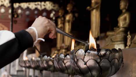 Menschen-Füllen-öl-In-Die-Kerzenhalter-In-Einem-Buddhistischen-Tempel-In-Dem-Glauben,-Dass-Dies-Ihr-Glück-Verbessern-Und-Unglück-Beseitigen-Wird