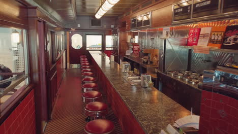 View-into-an-empty-nostalgic-old-fifties-Diner-with-lots-of-signs-and-a-bar-and-stools