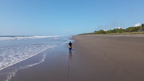 Person-riding-a-motor-bike-through-the-shallow-waves-that-crash-ashore-at-Playa-Palo-Seco,-Costa-Rica