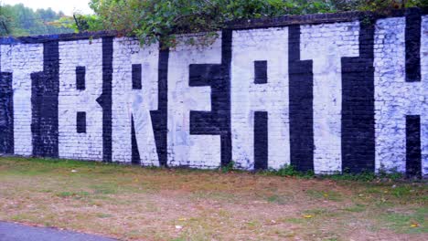 I-Can't-Breathe-graffiti-art-for-Black-Lives-Matter,-big-letters-on-a-wall-in-a-park-under-the-rain
