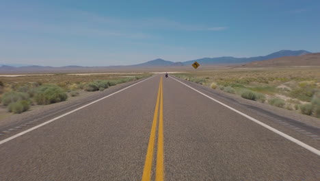 Americas-most-lonely-highway-filmed-from-the-middle-of-the-road-as-a-big-twin-motorcycle-start-to-ride-on-and-vanishes-in-the-distance