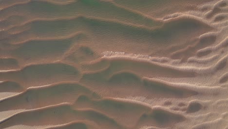 Drone-view-of-sand-formation-at-low-tide-with-wind-and-water-ripples