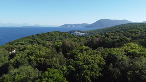 Flying-over-dense-green-forest-with-deep-blue-ocean