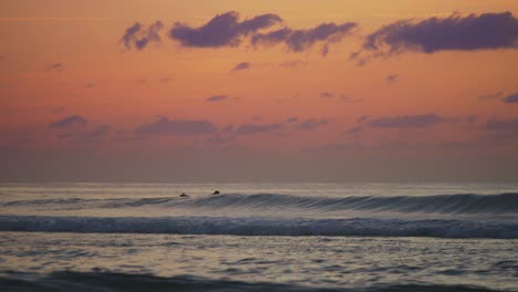 Surfer,-Der-Während-Des-Sonnenuntergangs-Im-Ozean-Paddelt