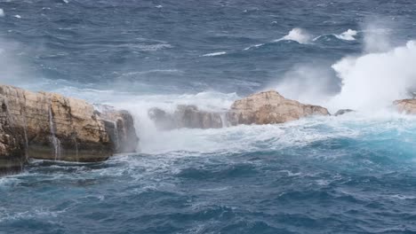 Gezackter-Felsen-Im-Ozean-Erzeugt-Wasserfall-Und-Unruhiges-Wasser