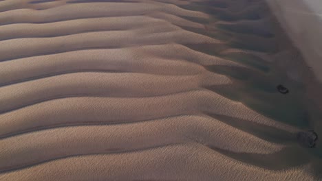 Sandy-dunes-overtook-by-rising-levels-of-water,-aerial-drone-view