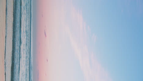 Ein-Wunderschöner-Rosa-Und-Blauer-Sonnenaufgang,-Sonnenuntergang-Mit-Meereswellen,-Die-Am-Strand-Aufrollen