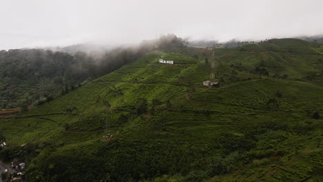 Aerial-View-Of-Lush-Green-Hills-On-A-Misty-Day-In-Indonesia---drone-shot