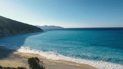 Hermosa-Playa-Larga-En-Una-Isla-Con-Impresionantes-Olas-Y-Mar-De-Color-Azul