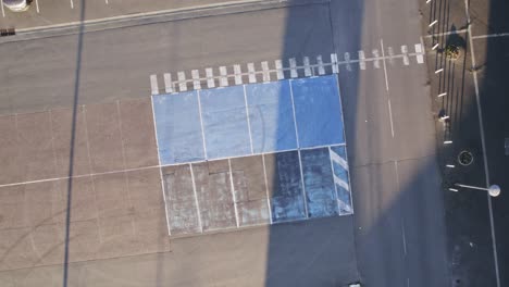 Parking-slots-marked-in-blue-color-for-disabled-people,-aerial-top-down-shot
