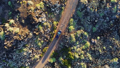 Schwarzes-Auto,-Das-Auf-Unbefestigten-Straßen-In-Felsiger-Berglandschaft-Fährt,-Luftaufnahme-Von-Oben-Nach-Unten