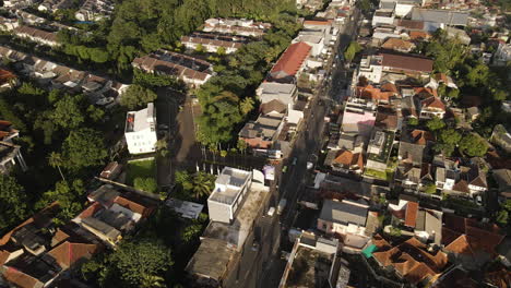 Luftaufnahme-Von-Fahrzeugen,-Die-Zwischen-Häusern-Und-Gebäuden-In-Jakarta,-Indonesien,-Vorbeifahren---Drohnenaufnahme