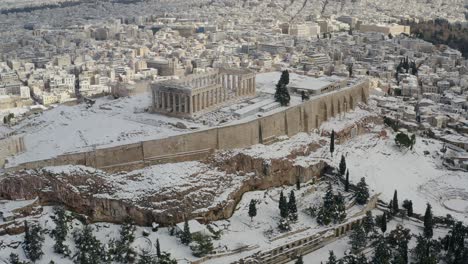 Aerial-drone-view-overlooking-the-snow-covered-Parthenon,-unique-winter-day-in-Athens,-Greece