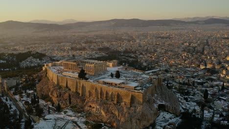 Aerial-view-around-the-Parthenon-temple,-rare-snowy-sunset-in-Athens,-Greece---circling,-drone-shot