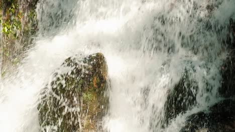 Close-up-view-of-river-waterfall-splash,-fast-forest-stream-falls-down-the-rocks,-static