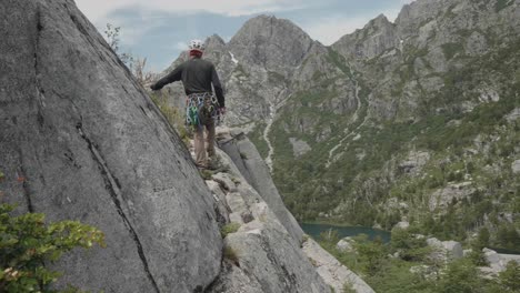 Climber-walking-on-a-ledge-of-a-pristine-granite-wall