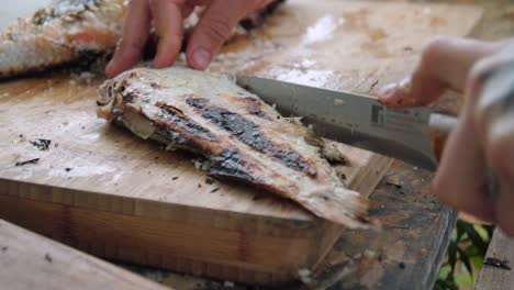 Deboning-a-grilled-fish-with-a-small-knife,-Close-Up