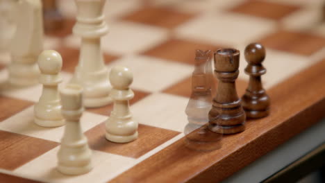 Chess-Game-Pieces,-Closeup-Of-Captured-Black-Pieces-Appearing-On-Edge-Of-Board,-Macro